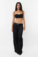 Pantalón negro de corte recto y tiro medio, con recortes en las piernas con detalle de vivo. Cintura con presillas y cinto correa con broche plástico incluido.