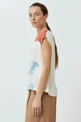 Blusa sin mangas con estampado floral en tonos celeste y naranja sobre fondo blanco. Presenta cuello redondo y corte recto.
