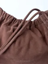 Bolso totebag negro de cuero con fruncido superior y doble asa fina.