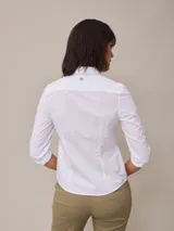 Camisa celeste a rayas verticales blancas, de manga 3/4 con puños arremangados y cuello clásico.