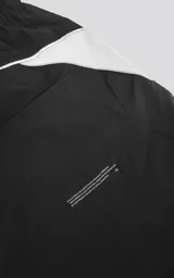 Bermuda negra con recortes blancos, calce oversize, textil liviano, elástico en la cintura, cordón de ajuste, bolsillos delanteros y traseros.