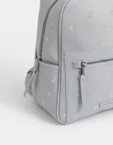 Mochila de cuerina color crema con estampado de flores bordadas, bolsillo frontal con cierre, correas regulables, manija superior, acceso con cierre superior, bolsillos laterales y tag de cuerina.