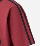 Remera deportiva masculina oversized color gris oscuro con cuello en V blanco, mangas cortas con rayas blancas, estampa localizada y lettering blanco.