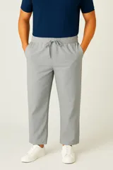 Pantalón de lino color gris claro, corte slim fit, tiro bajo, con cordón ajustable en la cintura y bolsillos laterales.