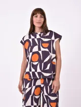 Remera de mangas cortas con estampado geométrico en tonos negro, blanco y naranja.