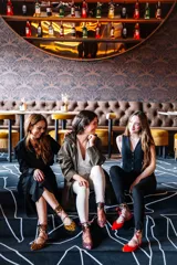 Bailarinas rojas de punta fina con talonera de animal print, pulsera tobillera de pelo de pony con estampado animal print y borlas rojas.