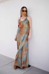 Vestido largo con tirantes finos y estampado tipo acuarela en tonos tierra y celeste.