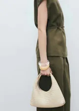 Pantalón de vestir verde oliva, de tiro medio y corte recto. Presenta cierre frontal oculto, bolsillos laterales y pinzas delanteras.