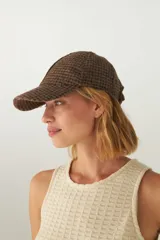 Gorra con visera de lana color beige con diseño de espiga.