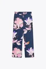 Pantalón de tiro alto con estampado de flores rosas y lilas sobre fondo azul marino. Tiene bolsillos delanteros y falsos bolsillos traseros. La cintura es elástica y ajustable con cordones.