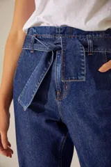 Pantalón oxford de denim azul con bolsillos delanteros y lazo desmontable en la cintura.