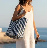 Bolso tote de tela color crudo con rayas verticales azules.