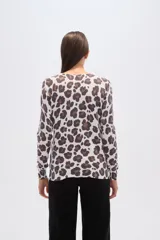Sweater de tejido de punto, color crema, con estampado floral en tonos rosados y marrones. Presenta cuello redondo y mangas largas.