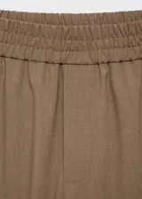 Pantalón wideleg color marrón claro, con cintura elástica, tiro medio, sin cierre, dos bolsillos laterales, estilo jogger y forro interior.