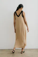 Vestido midi negro con escote en V, breteles finos con volados blancos y tajos laterales.