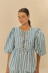 Blusa de rayas verticales celestes y blancas con mangas abullonadas y lazos en el escote.