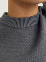 Sweater gris de tejido de punto con cuello redondo y mangas largas.