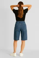 Bermuda de jean negro lavado, tiro alto, corte recto y ancho que llega hasta la rodilla.