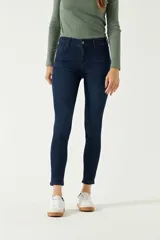 Jean skinny de tiro alto, largo a los tobillos, confeccionado en 98% algodón y 2% elastano.