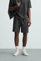 Bermuda negra de corte relaxed fit, con cintura elástica ajustable con cordón, bolsillos frontales y bolsillo trasero de parche.