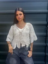 Camisa negra con detalles de crochet color crema, escote en V y mangas 3/4.