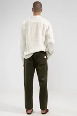 Camisa de manga larga color blanco hueso, confeccionada en lino, con cuello clásico y cierre frontal con botones de coco.