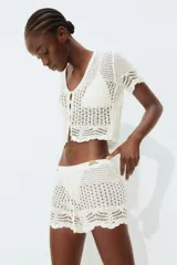 Short de playa tejido al crochet color blanco, con cintura elástica y cordón de ajuste.