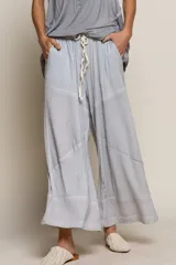 Pantalón palazzo celeste con cintura elastizada con cordón ajustable, bolsillos laterales y diseño patchwork con secciones de tejido liso y tejido texturizado.