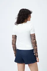 Remera color beige con cuello redondo y mangas cortas. Presenta un estampado con relieve de un corazón con un caballo en su interior y la frase "wild hearts can't be broken".