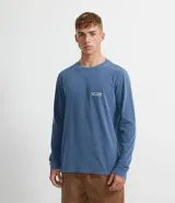 Remera de manga larga azul con cuello redondo y estampado pequeño en el pecho.