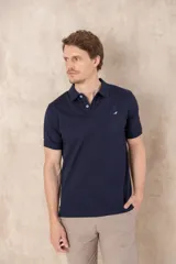 Chomba azul con cuello clásico, tapeta de dos botones y logo bordado en el pecho.