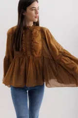 Camisa color marrón con cuello mao, mangas largas abullonadas y detalle de volados en el frente.