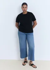 Remera negra de algodón, de corte recto, manga corta y cuello redondo.