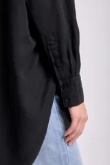 Camisa negra de liocel con cuello clásico, cierre frontal con botones, manga larga y bolsillo de parche en el pecho.