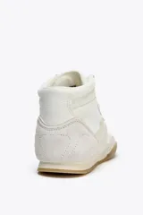 Botín deportivo blanco con detalles en beige y suela color caramelo. Cierre con cordones y puntera redonda.