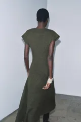 Vestido largo de punto color verde oscuro, con cuello redondo, manga corta y bajo en evasé.