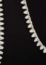 Musculosa negra de algodón con ribete blanco en cuello y sisas, corte ajustado y cuello redondo.