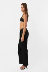 Pantalón negro de tiro medio y corte recto con cartera en diagonal y cintura larga.