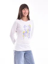 Remera blanca de manga larga con cuello redondo y estampado de flores en tonos lila y amarillo.