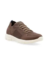 Sneaker azul marino de tejido de punto con cordones elásticos, suela blanca de goma y tirador naranja en el talón.