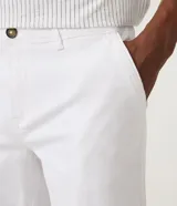 Bermuda masculina de corte slim, confeccionada en sarga lisa color blanco. Cuenta con bolsillos laterales, cierre con botón y cremallera, y trabillas para cinturón.