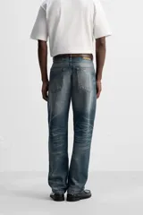 Pantalón de jean azul con efecto lavado, corte recto y largo al tobillo.