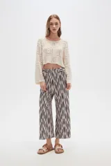 Pantalón recto de poliéster con estampado a rayas verticales en blanco y negro.