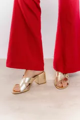 Sandalia tipo zueco de charol rojo con hebilla dorada y taco cuadrado.