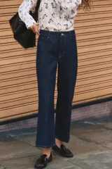 Pantalón de jean azul oscuro, de tiro alto y corte recto con pernera ancha.