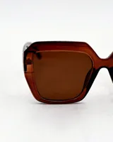 Lentes de sol con marco geométrico color marrón y lentes marrones.