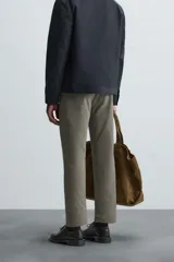 Pantalón chino de vestir negro, corte slim fit, con bolsillos laterales y traseros. Cierre frontal con cremallera y botón.