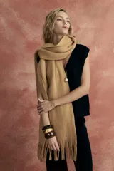 Bufanda larga color beige con flecos en los extremos.