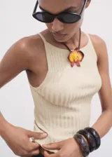 Top sin mangas de tejido de punto fino color beige claro, con cuello barco y tirantes finos, de diseño entallado.