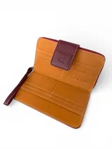 Billetera tipo clutch o cartera de mano, color vino tinto, con textura de cuero cocodrilo (crocco). Presenta un cierre de solapa con broche y costuras en contraste color claro. Incluye una correa de muñeca desmontable.